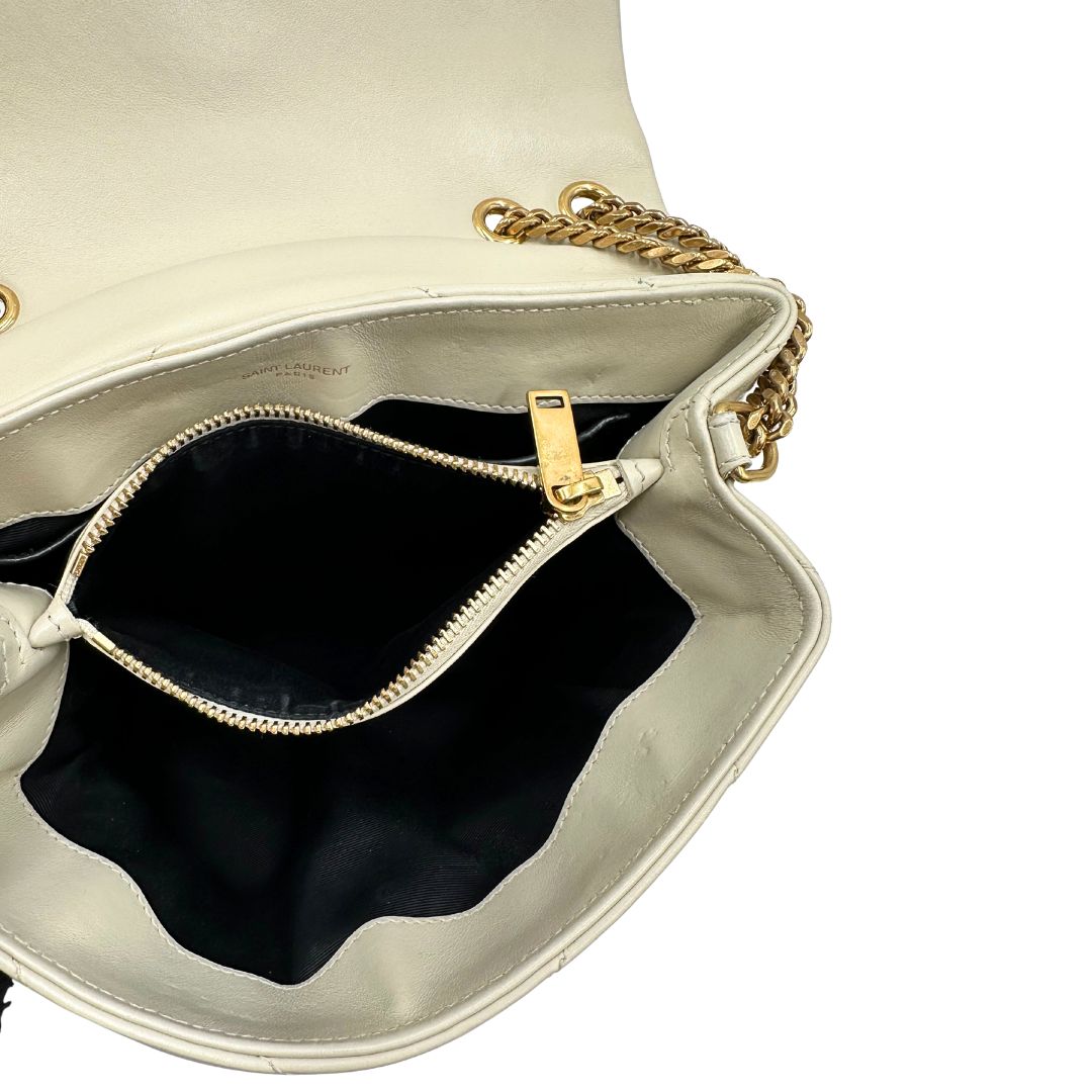 Interno di una borsa Saint Laurent in pelle trapuntata bianco latte con tracolla scorrevole in catena e spallacci in pelle, con parti metalliche dorate e iconico logo Cassandre sul front. Completa di dustbag. Indossabile a spalla o a tracolla.