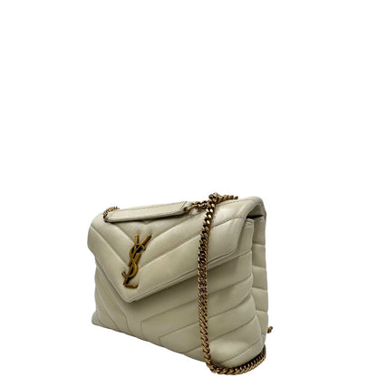 Laterale destro di una borsa Saint Laurent in pelle trapuntata bianco latte con tracolla scorrevole in catena e spallacci in pelle, con parti metalliche dorate e iconico logo Cassandre sul front. Completa di dustbag. Indossabile a spalla o a tracolla.