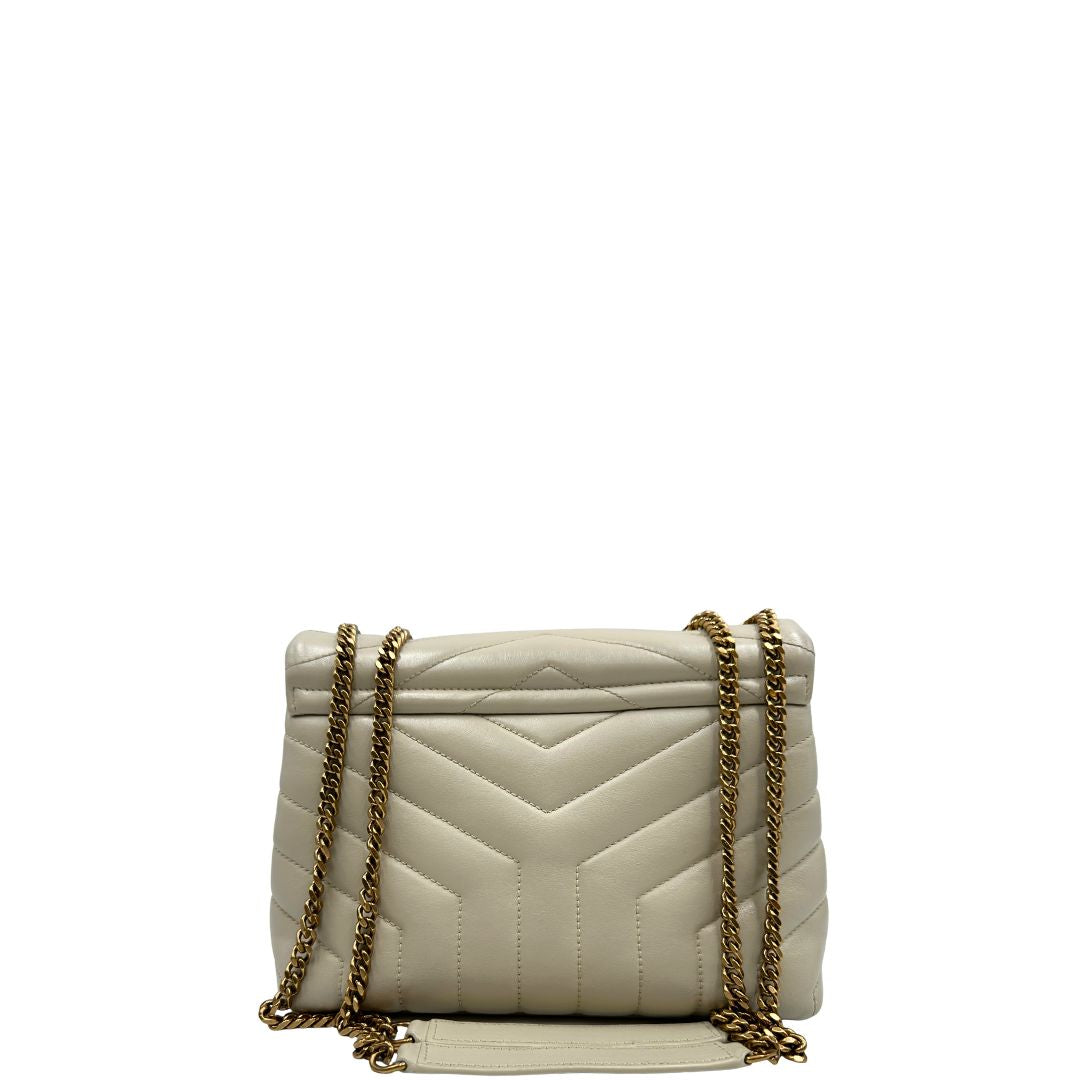 Retro di una borsa Saint Laurent in pelle trapuntata bianco latte con tracolla scorrevole in catena e spallacci in pelle, con parti metalliche dorate e iconico logo Cassandre sul front. Completa di dustbag. Indossabile a spalla o a tracolla.