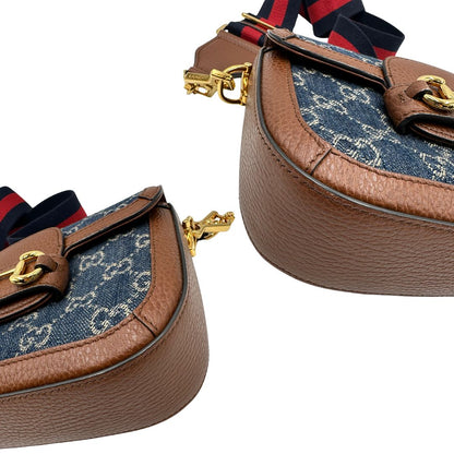 Angoli di una borsa Gucci in tessuto effetto denim con trama GG , finiture in pelle marroni e parti metalliche dorate; munita di una tracolla Web in tessuto blu e rossa e una tracolla in pelle, entrambe amovibili e regolabili. Completa di dustbag.