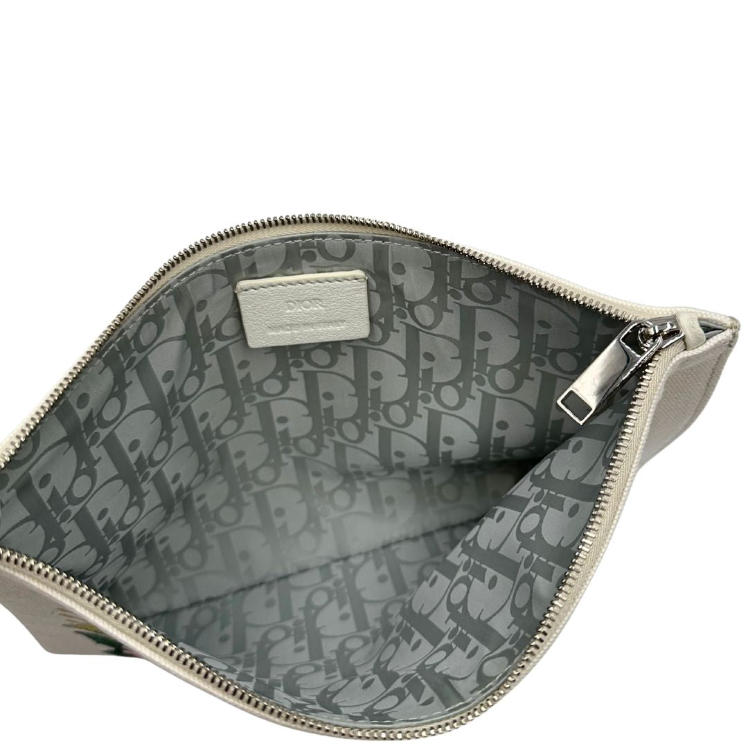Interno di una pochette Dior in tela bianco latte con stampa motivo floreale multicolore e parti metalliche argentate. Munita di dustbag.