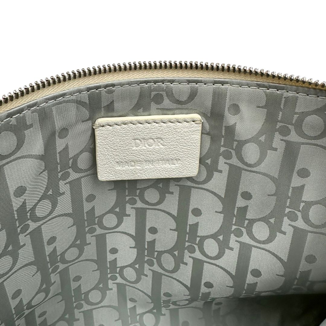 Interno di una pochette Dior in tela bianco latte con stampa motivo floreale multicolore e parti metalliche argentate. Munita di dustbag.