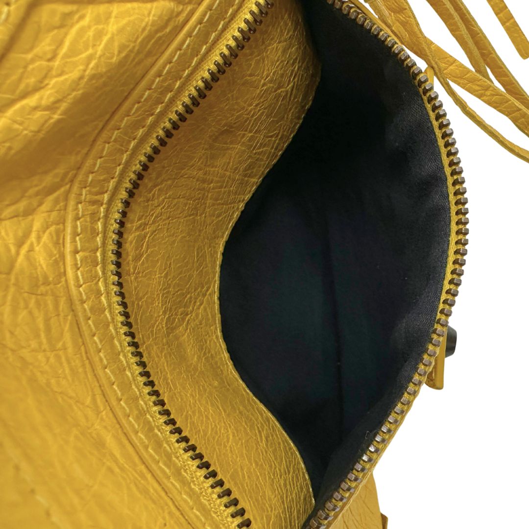 interno  Pochette Balenciaga in pelle effetto invecchiato gialla con metalleria color bronzo anticato scuro; munita di un polsino amovibile, da portare a mano, di lusso, originale, ottime condizioni, usata. 