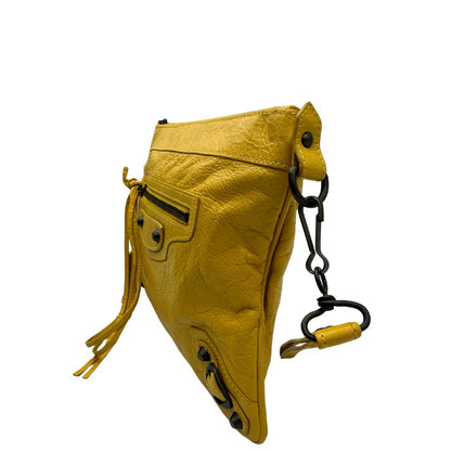 lato  Pochette Balenciaga in pelle effetto invecchiato gialla con metalleria color bronzo anticato scuro; munita di un polsino amovibile, da portare a mano, di lusso, originale, ottime condizioni, usata. 