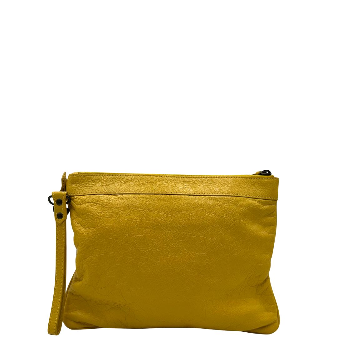 retro   Pochette Balenciaga in pelle effetto invecchiato gialla con metalleria color bronzo anticato scuro; munita di un polsino amovibile, da portare a mano, di lusso, originale, ottime condizioni, usata.