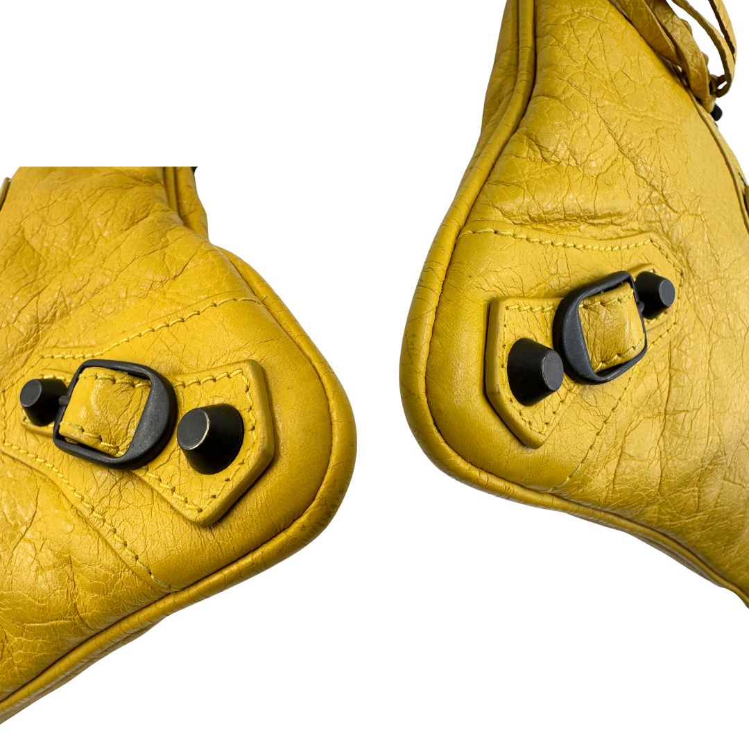 angoli  Pochette Balenciaga in pelle effetto invecchiato gialla con metalleria color bronzo anticato scuro; munita di un polsino amovibile, da portare a mano, di lusso, originale, ottime condizioni, usata.