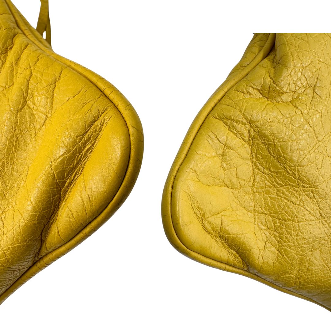 angoli  Pochette Balenciaga in pelle effetto invecchiato gialla con metalleria color bronzo anticato scuro; munita di un polsino amovibile, da portare a mano, di lusso, originale, ottime condizioni, usata. 