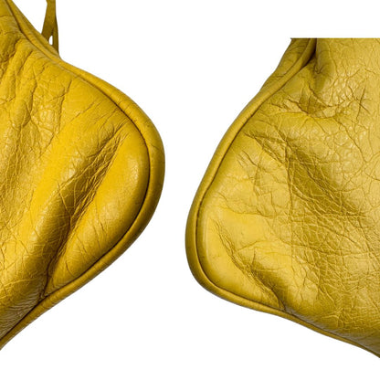 angoli  Pochette Balenciaga in pelle effetto invecchiato gialla con metalleria color bronzo anticato scuro; munita di un polsino amovibile, da portare a mano, di lusso, originale, ottime condizioni, usata. 