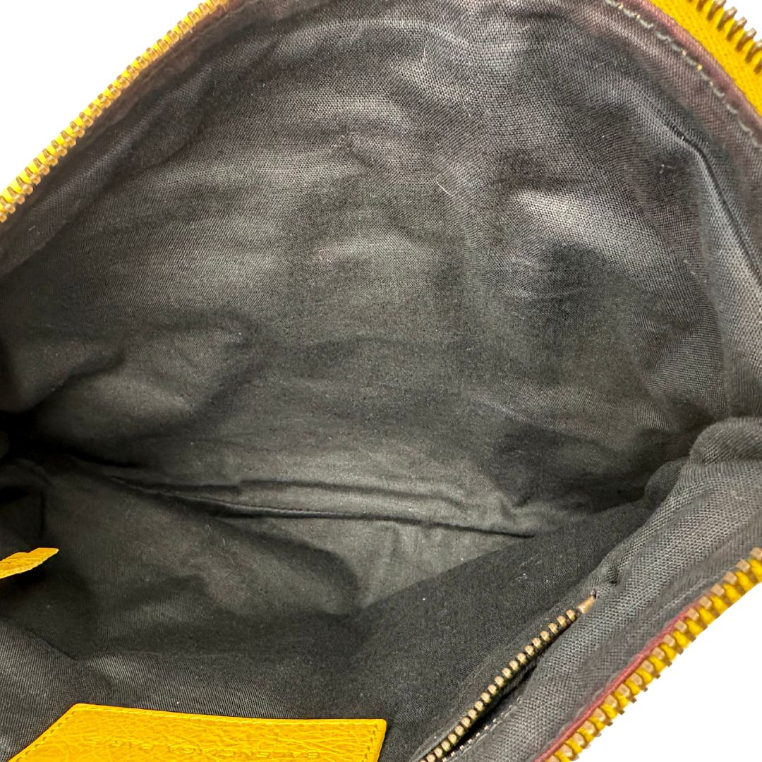 interno  Pochette Balenciaga in pelle effetto invecchiato gialla con metalleria color bronzo anticato scuro; munita di un polsino amovibile, da portare a mano, di lusso, originale, ottime condizioni, usata. 