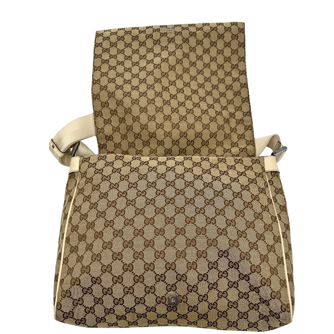 Apertura di una borsa Gucci in tessuto beige GG , von finiture in pelle bianco avorio con parti metalliche argentate. Munita di tracolla regolabile e non amovibile, in tessuto con spallaccio in pelle. Completa di dustbag. Indossabile a tracolla.