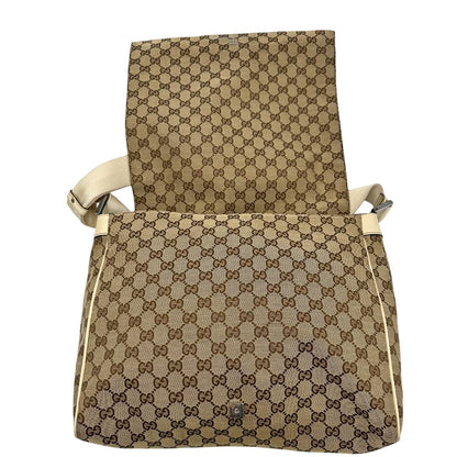 Apertura di una borsa Gucci in tessuto beige GG , von finiture in pelle bianco avorio con parti metalliche argentate. Munita di tracolla regolabile e non amovibile, in tessuto con spallaccio in pelle. Completa di dustbag. Indossabile a tracolla.