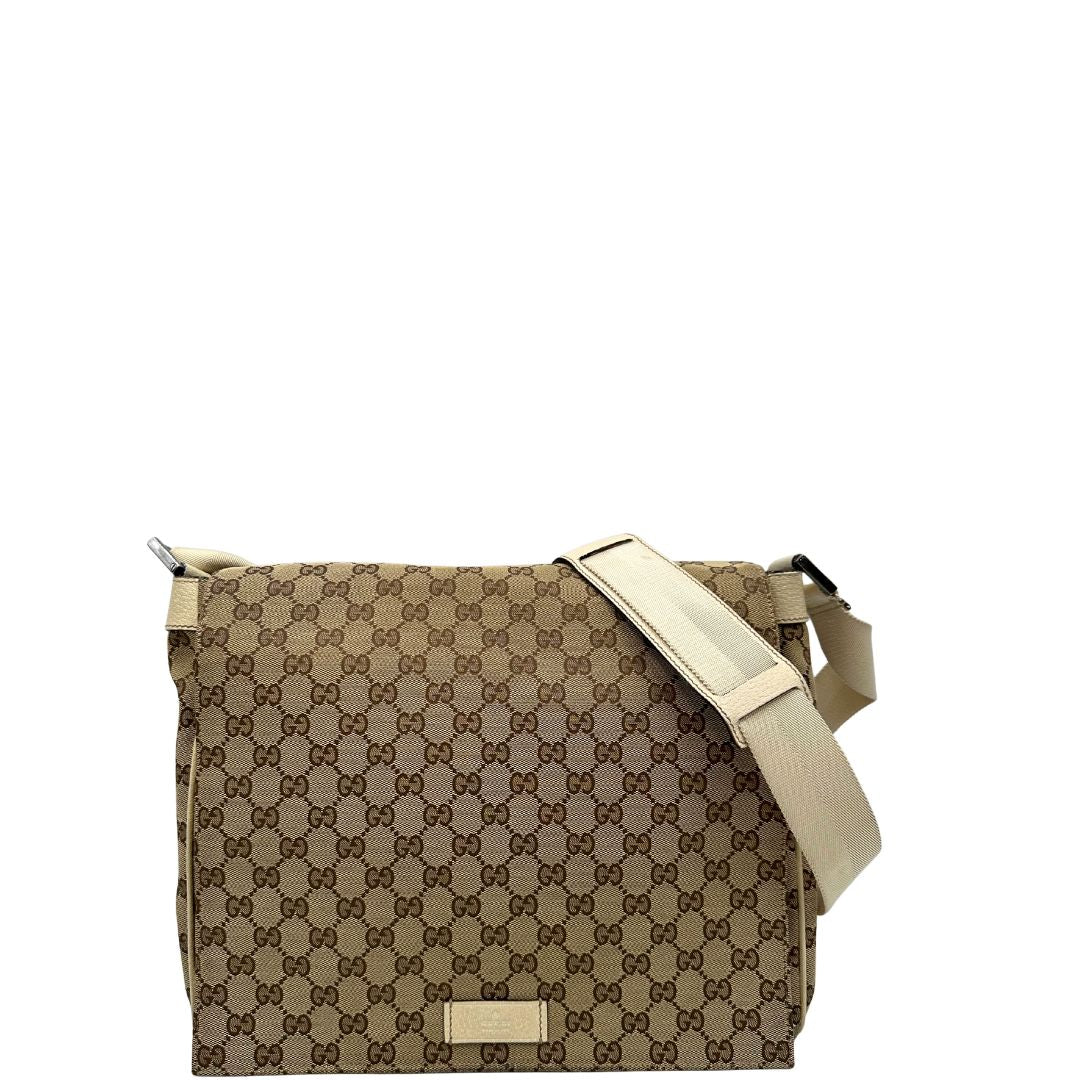 Front di una borsa Gucci in tessuto beige GG , von finiture in pelle bianco avorio con parti metalliche argentate. Munita di tracolla regolabile e non amovibile, in tessuto con spallaccio in pelle. Completa di dustbag. Indossabile a tracolla.