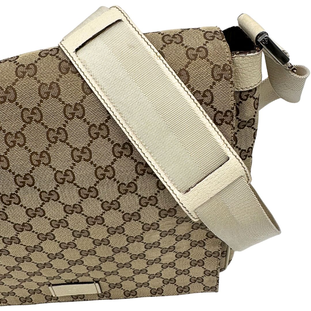 Tracolla di una borsa Gucci in tessuto beige GG , von finiture in pelle bianco avorio con parti metalliche argentate. Munita di tracolla regolabile e non amovibile, in tessuto con spallaccio in pelle. Completa di dustbag. Indossabile a tracolla.