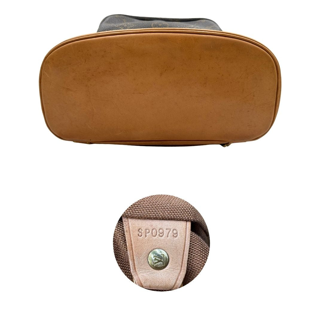 Base e codice di uno zaino Montsouris mini in canvas marrone monogram con finiture in vacchetta naturale e parti metalliche dorate, munito di un anello sulla parte superiore e due bretelle in vacchetta regolabili con fibbie. Completo di dustbag.