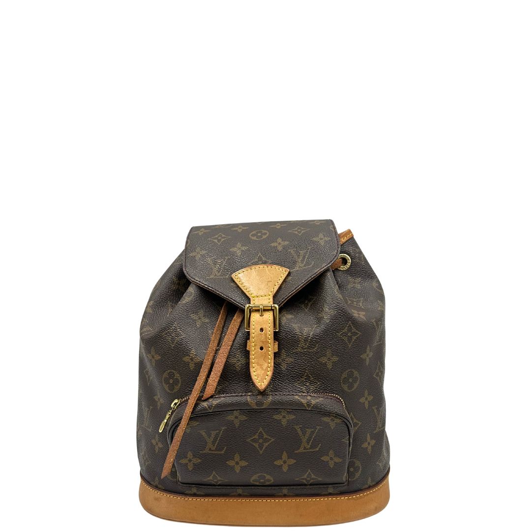 Front di uno zaino Montsouris mini in canvas marrone monogram con finiture in vacchetta naturale e parti metalliche dorate, munito di un anello sulla parte superiore e due bretelle in vacchetta regolabili con fibbie. Completo di dustbag.