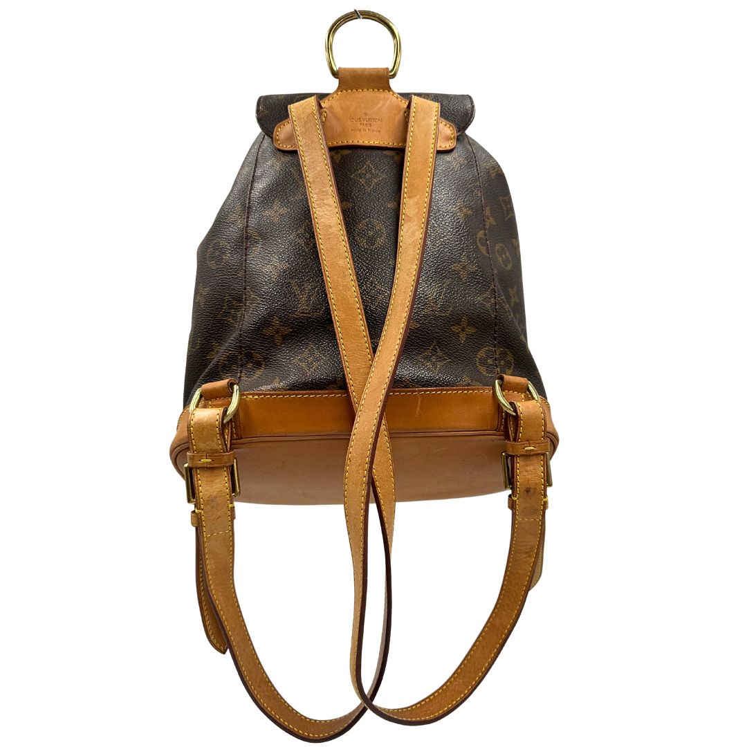 Retro di uno zaino Montsouris mini in canvas marrone monogram con finiture in vacchetta naturale e parti metalliche dorate, munito di un anello sulla parte superiore e due bretelle in vacchetta regolabili con fibbie. Completo di dustbag.