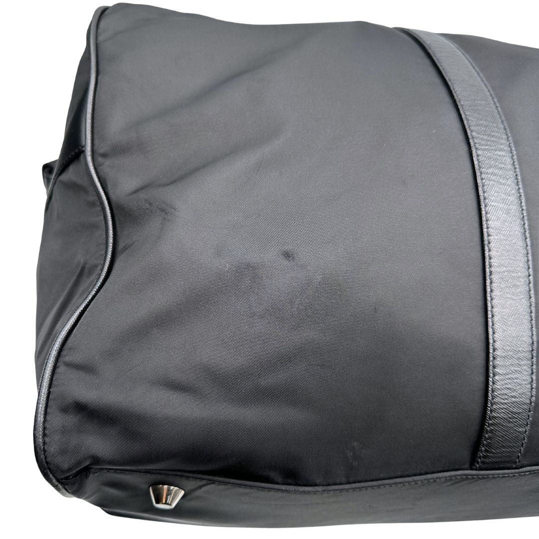 angoli  Borsone Prada in nylon nero con finiture in pelle tono su tono e parti metalliche argentate; munito di doppi manici stondati e un manico singolo in tessuto, indossabile a spalla o mano. Completo di dustbag e tag porta address, di lusso, originale, ottime condizioni, usata. 