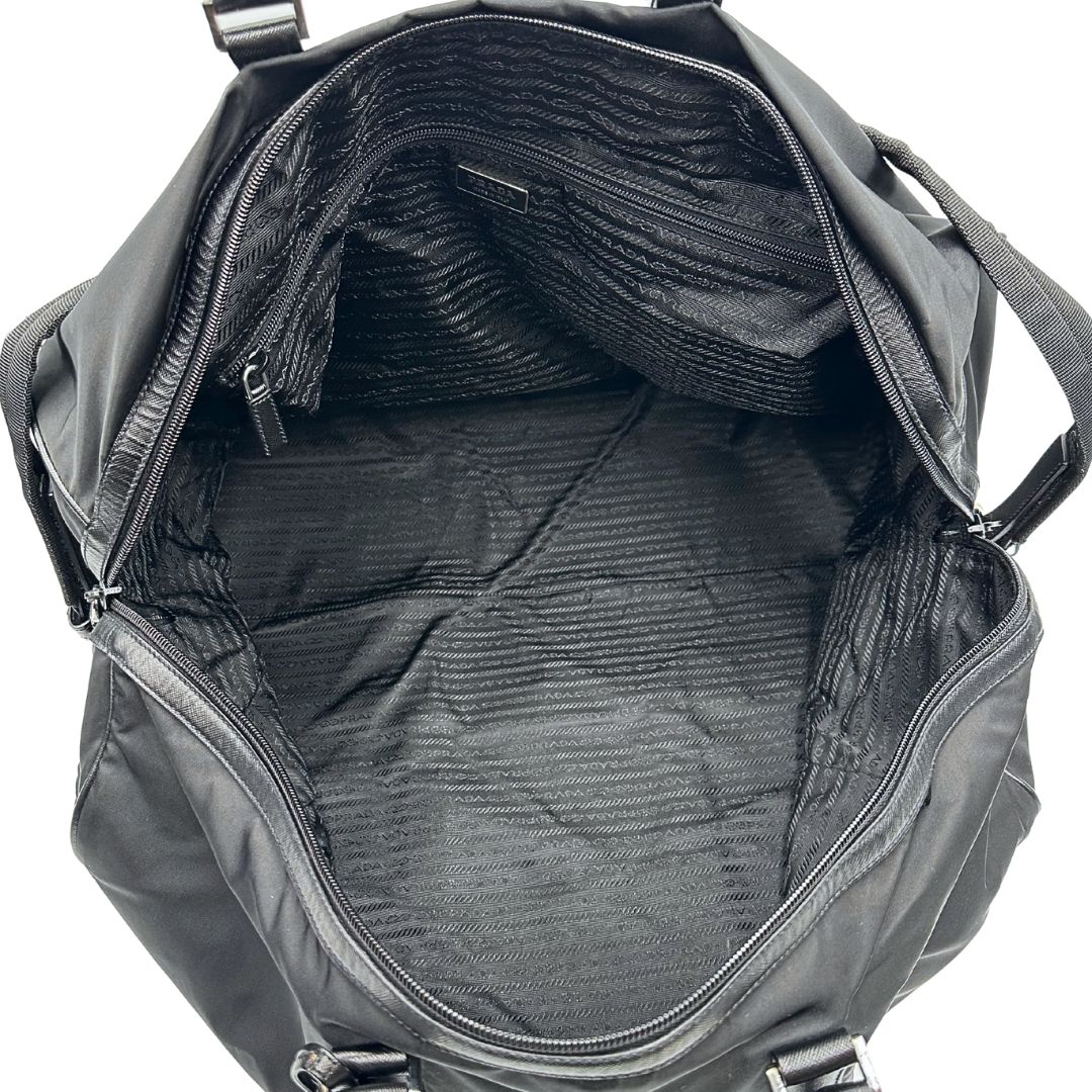 interno  Borsone Prada in nylon nero con finiture in pelle tono su tono e parti metalliche argentate; munito di doppi manici stondati e un manico singolo in tessuto, indossabile a spalla o mano. Completo di dustbag e tag porta address, di lusso, originale, ottime condizioni, usata. 