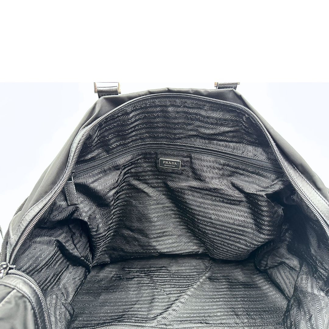 interno  Borsone Prada in nylon nero con finiture in pelle tono su tono e parti metalliche argentate; munito di doppi manici stondati e un manico singolo in tessuto, indossabile a spalla o mano. Completo di dustbag e tag porta address, di lusso, originale, ottime condizioni, usata. 