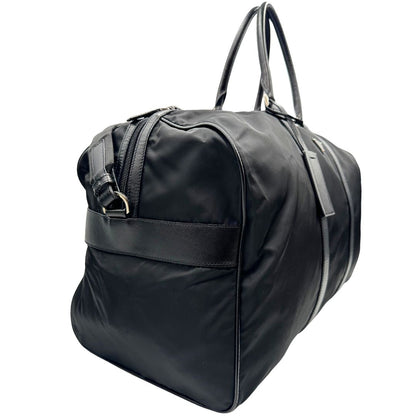 lato  Borsone Prada in nylon nero con finiture in pelle tono su tono e parti metalliche argentate; munito di doppi manici stondati e un manico singolo in tessuto, indossabile a spalla o mano. Completo di dustbag e tag porta address, di lusso, originale, ottime condizioni, usata. 