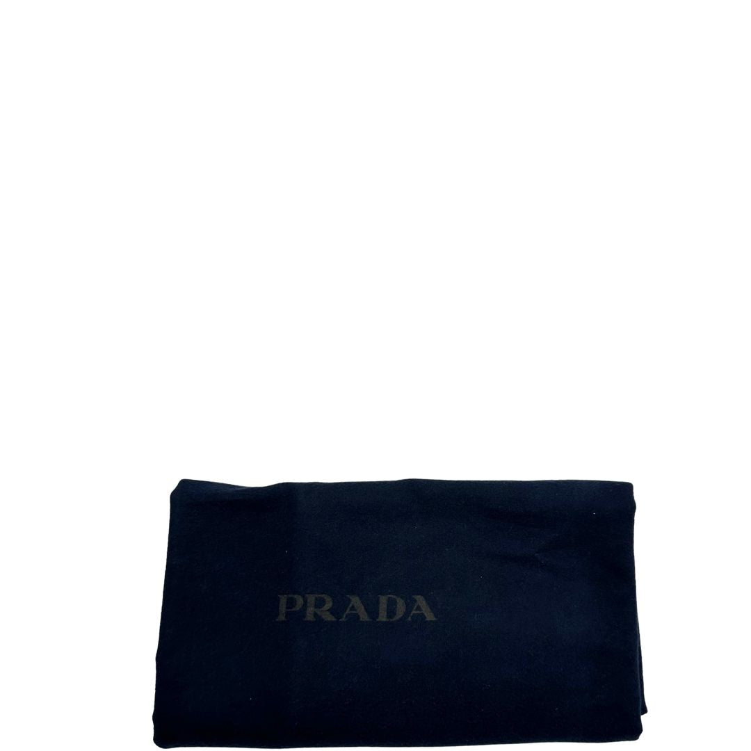 Dustbag di un borsone Prada in nylon nero con finiture in pelle Saffiano tono su tono e parti metalliche argentate. Completo di tag porta address e lucchetto. Indossabile a mano.
