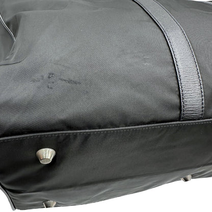 Difetto di un borsone Prada in nylon nero con finiture in pelle Saffiano tono su tono e parti metalliche argentate. Completo di dustbag, tag porta address e lucchetto. Indossabile a mano.