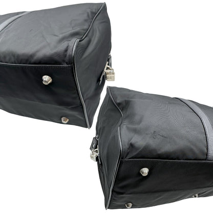 Angoli di un borsone Prada in nylon nero con finiture in pelle Saffiano tono su tono e parti metalliche argentate. Completo di dustbag, tag porta address e lucchetto. Indossabile a mano.