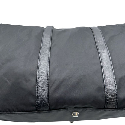 Difetto di un borsone Prada in nylon nero con finiture in pelle Saffiano tono su tono e parti metalliche argentate. Completo di dustbag, tag porta address e lucchetto. Indossabile a mano.