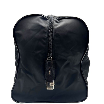 Vista laterale di un borsone Prada in nylon nero con finiture in pelle Saffiano tono su tono e parti metalliche argentate. Completo di dustbag, tag porta address e lucchetto. Indossabile a mano.