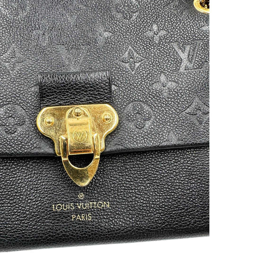 Chiusura metallica di una borsa Louis Vuitton in pelle blu notte Monogram Empreinte, con parti metalliche dorate; munita di una tracolla scorrevole con spallacci in pelle. Completa di scatola.