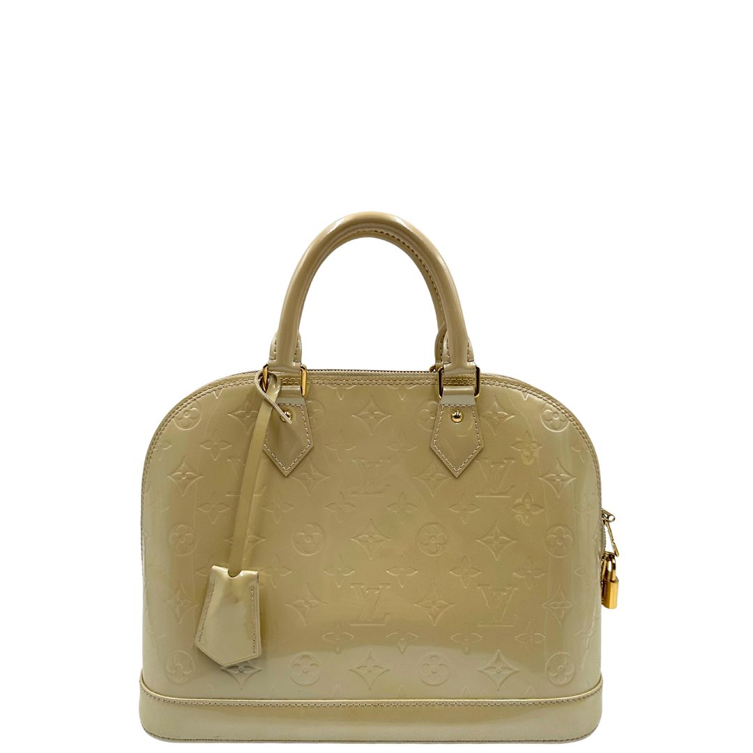 Front di una borsa Alma PM Louis Vuitton in pelle Vernis color noisette con parti metalliche dorate e doppi manici stondati; da portare a mano. Completa di lucchetto e chiavi. Indossabile a mano.