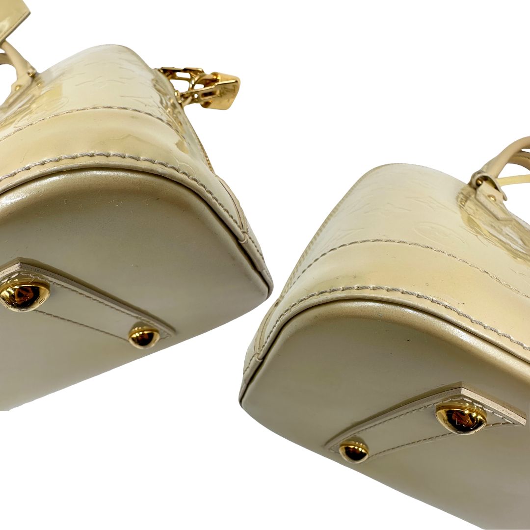 Angoli di una borsa Alma PM Louis Vuitton in pelle Vernis color noisette con parti metalliche dorate e doppi manici stondati; da portare a mano. Completa di lucchetto e chiavi. Indossabile a mano.