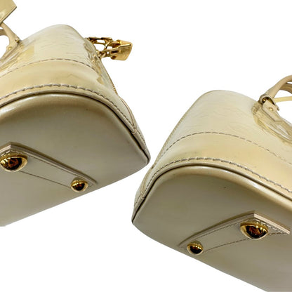 Angoli di una borsa Alma PM Louis Vuitton in pelle Vernis color noisette con parti metalliche dorate e doppi manici stondati; da portare a mano. Completa di lucchetto e chiavi. Indossabile a mano.