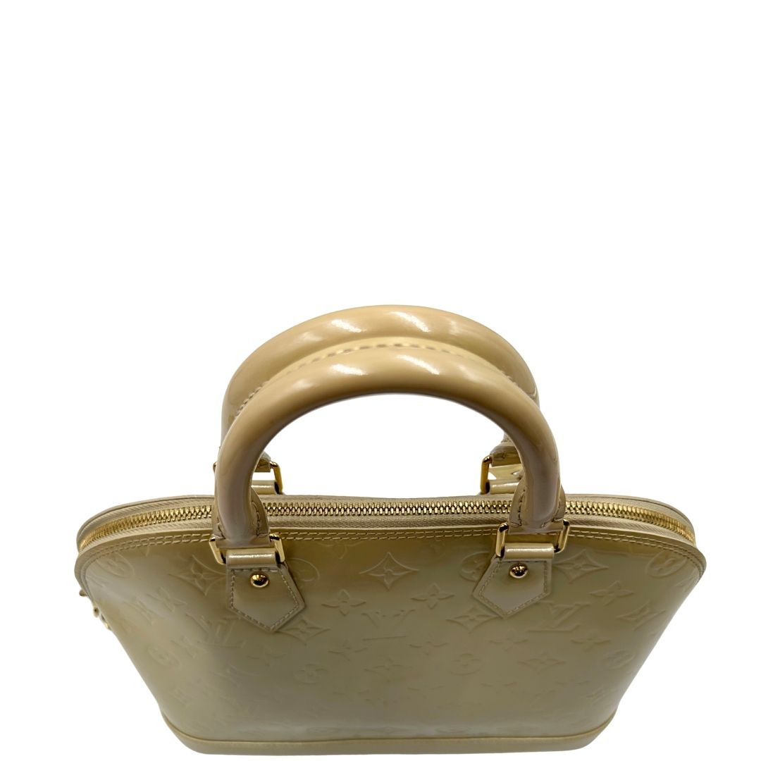 Manici di una borsa Alma PM Louis Vuitton in pelle Vernis color noisette con parti metalliche dorate e doppi manici stondati; da portare a mano. Completa di lucchetto e chiavi. Indossabile a mano.