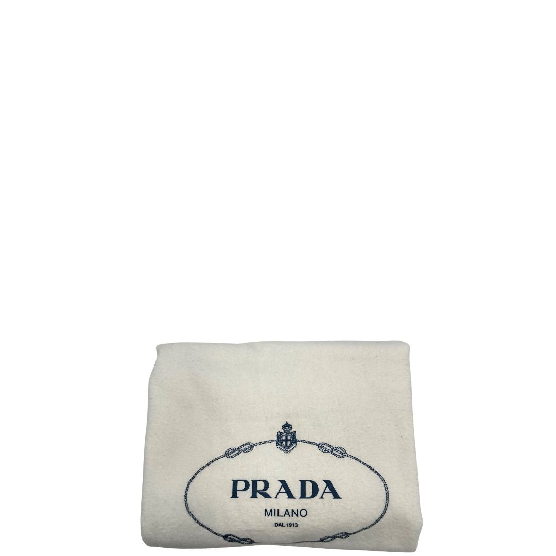 Dustbag di una borsa Prada in pelle bluette con parti metalliche dorate; munita di un accessorio porta address, doppi manici stondati e una tracolla amovibile e regolabile. Completa di card d'autenticità. Indossabile a mano oppure a tracolla.