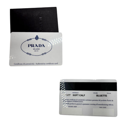 Card di una borsa Prada in pelle bluette con parti metalliche dorate; munita di un accessorio porta address, doppi manici stondati e una tracolla amovibile e regolabile. Completa di dustbag e card d'autenticità. Indossabile a mano oppure a tracolla.