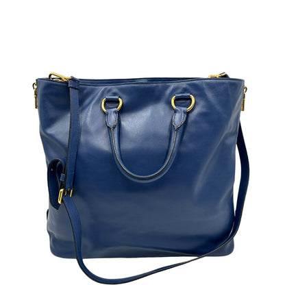 Retro di una borsa Prada in pelle bluette con parti metalliche dorate; munita di un accessorio porta address, doppi manici stondati e una tracolla amovibile e regolabile. Completa di dustbag e card d'autenticità. Indossabile a mano oppure a tracolla.