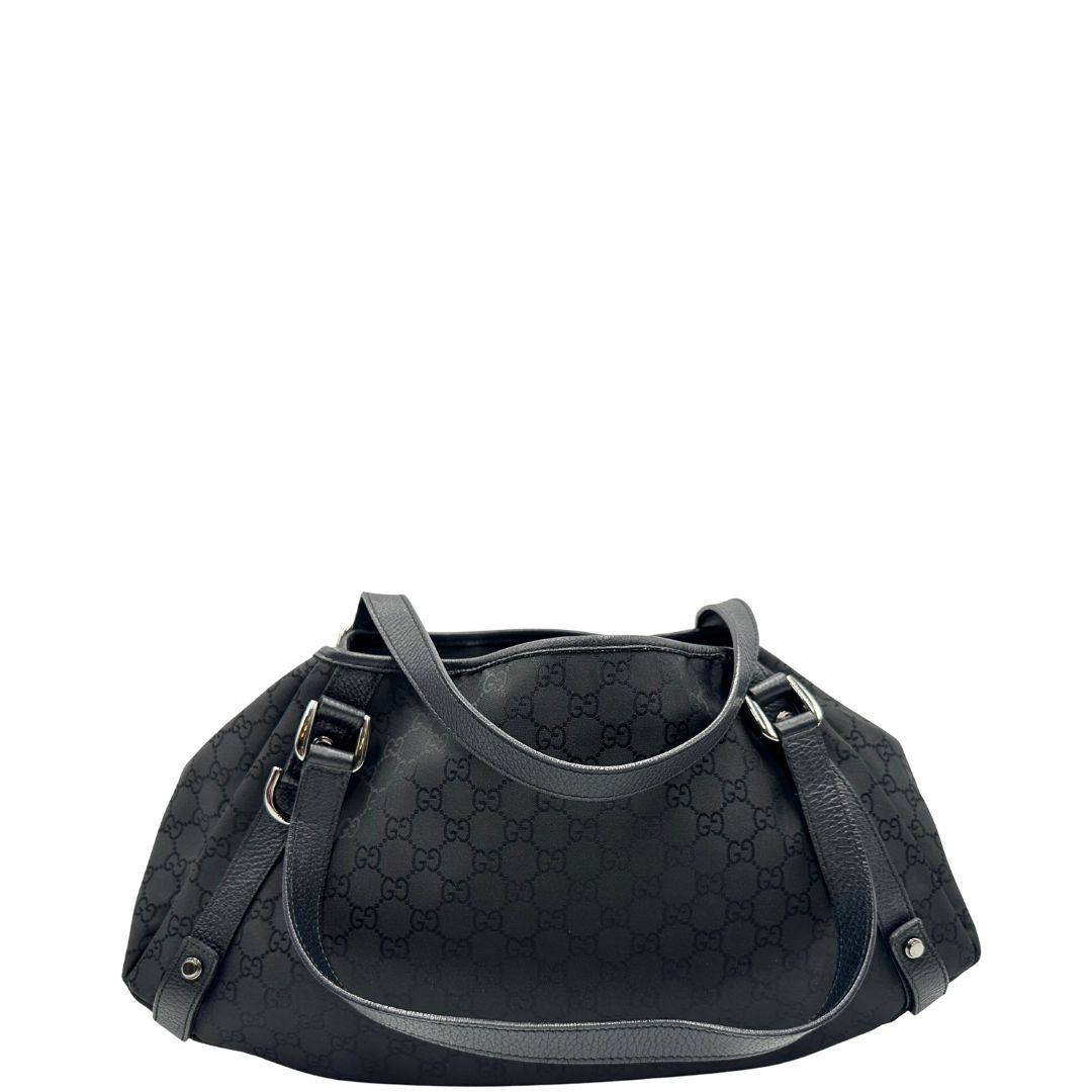 Retro di una borsa Gucci in tessuto nero GG con finiture in pelle tono su tono e parti metalliche argentate; munita di doppi manici, indossabile a spalla. Completa di dustbag.