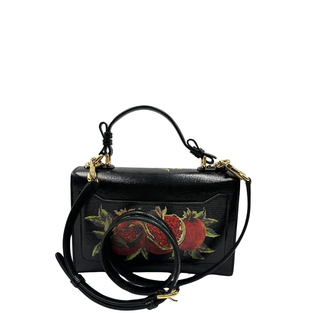 Retro di una borsa D&G in pelle nera con stampa melograni e parti metalliche dorate; munita di un manico rigido fisso e una tracolla in pelle regolabile ed amovibile. Completa di dustbag.