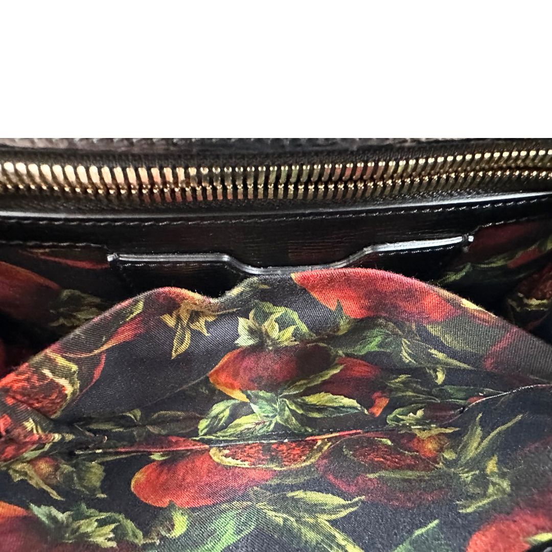 Interno di una borsa D&G in pelle nera con stampa melograni e parti metalliche dorate; munita di un manico rigido fisso e una tracolla in pelle regolabile ed amovibile. Completa di dustbag.