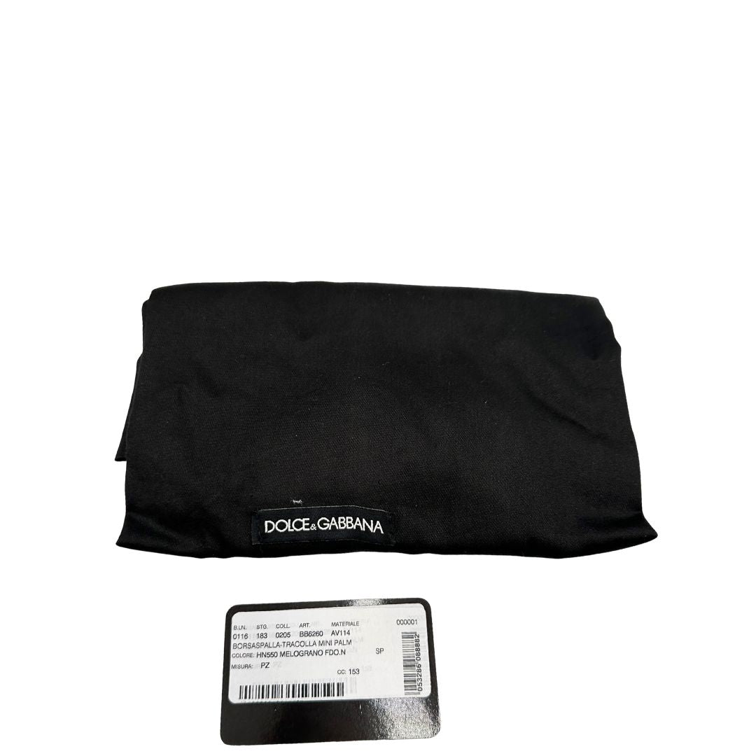 Dustbag di una borsa D&G in pelle nera con stampa melograni e parti metalliche dorate; munita di un manico rigido fisso e una tracolla in pelle regolabile ed amovibile.