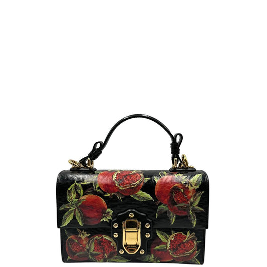 Front di una borsa D&G in pelle nera con stampa melograni e parti metalliche dorate; munita di un manico rigido fisso e una tracolla in pelle regolabile ed amovibile. Completa di dustbag.