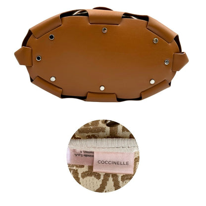 Base e codice di una borsa Coccinelle in pelle color cammello con parti metalliche argentate e interno in tessuto logato; munita di un manico singolo leggermente regolabile. Indossabile a spalla.