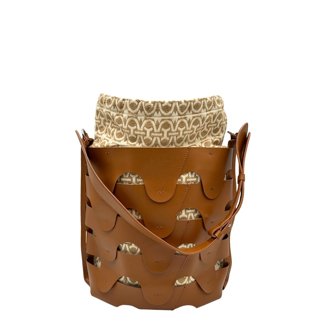 Front di una borsa Coccinelle in pelle color cammello con parti metalliche argentate e interno in tessuto logato; munita di un manico singolo leggermente regolabile. Indossabile a spalla.