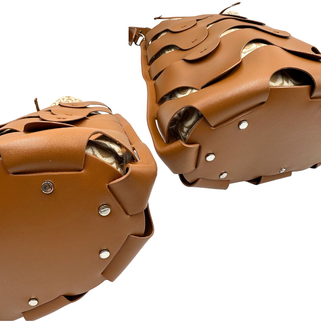 Angoli di una borsa Coccinelle in pelle color cammello con parti metalliche argentate e interno in tessuto logato; munita di un manico singolo leggermente regolabile. Indossabile a spalla.