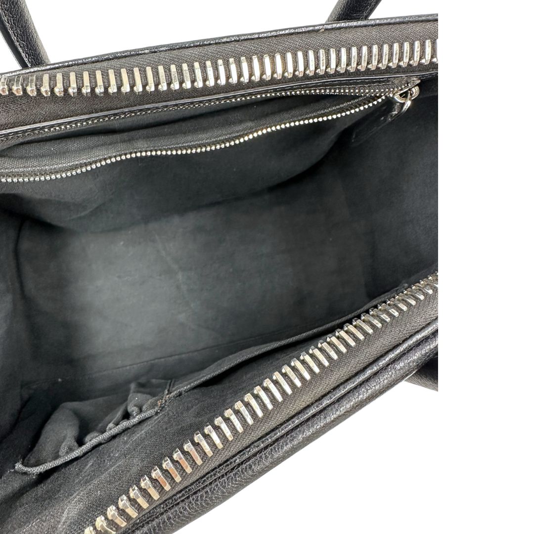 Interno di una borsa Givenchy Antigona in pelle nera dalla metalleria argentata, usata, originale, second hand, in ottime condizioni.