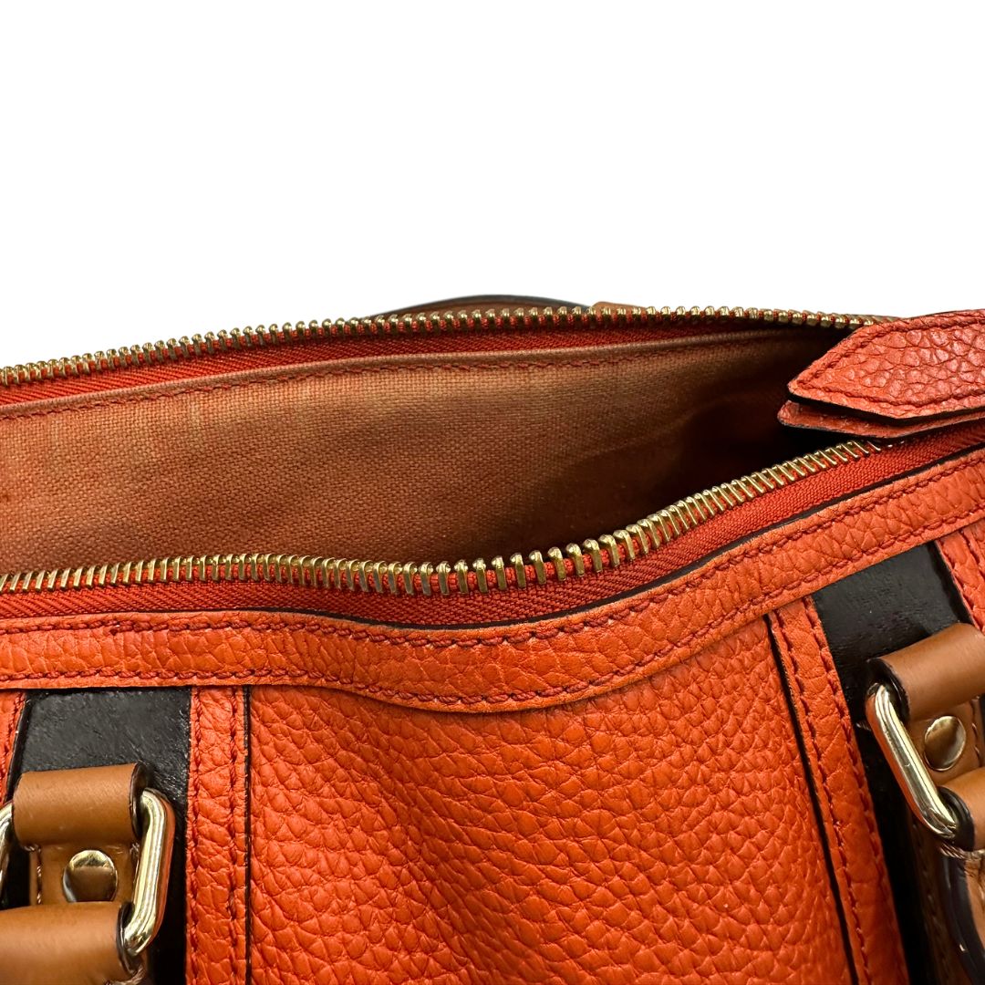 Chiusura di un bauletto Burberry arancione usato, originale, in ottime condizioni, second hand.