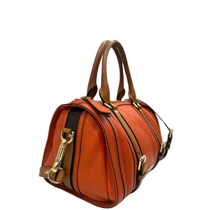 Laterale sinistro di un bauletto Burberry arancione usato, originale, in ottime condizioni, second hand.