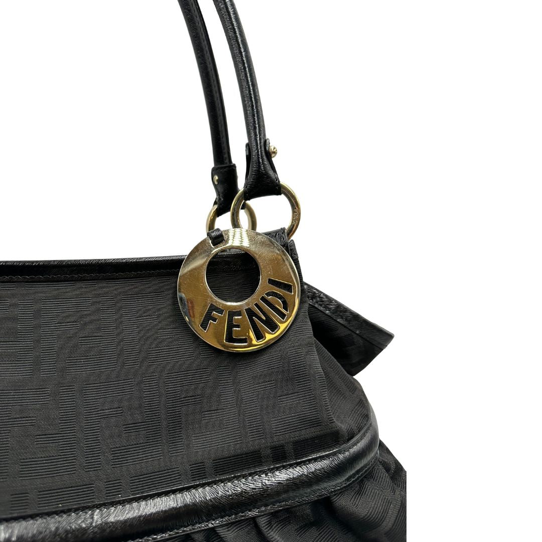 Charm logato decorativo di una borsa a spalla Fendi Chef in tessuto trama Zucca nero e metalleria oro chiaro, usata, originale, second hand, in ottime condizioni.