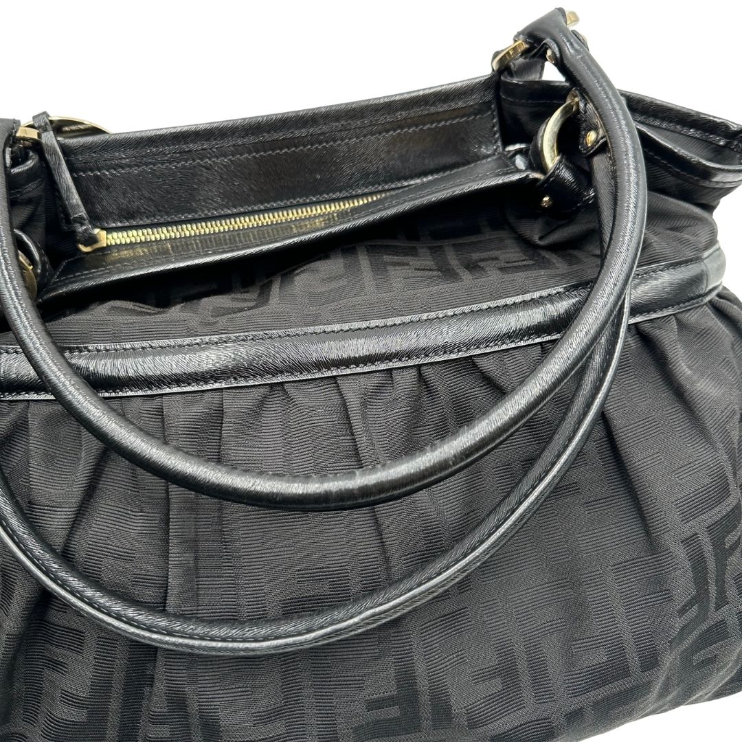 Manici di una borsa a spalla Fendi Chef in tessuto trama Zucca nero e metalleria oro chiaro, usata, originale, second hand, in ottime condizioni.